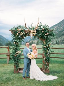 320 Ranch Wedding Bride and Groom in front of Floral Ceremony Arch